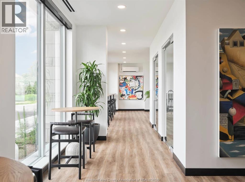 A long hallway with a wooden floor and a painting on the wall.