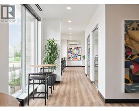A long hallway with a wooden floor and a painting on the wall.
