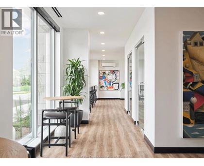 A long hallway with a wooden floor and a painting on the wall.