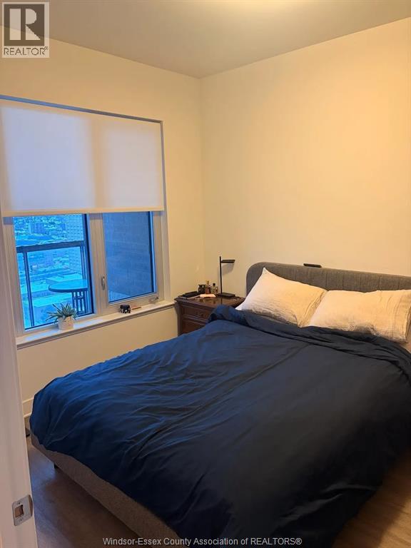 A bedroom with a bed, nightstand, and window.