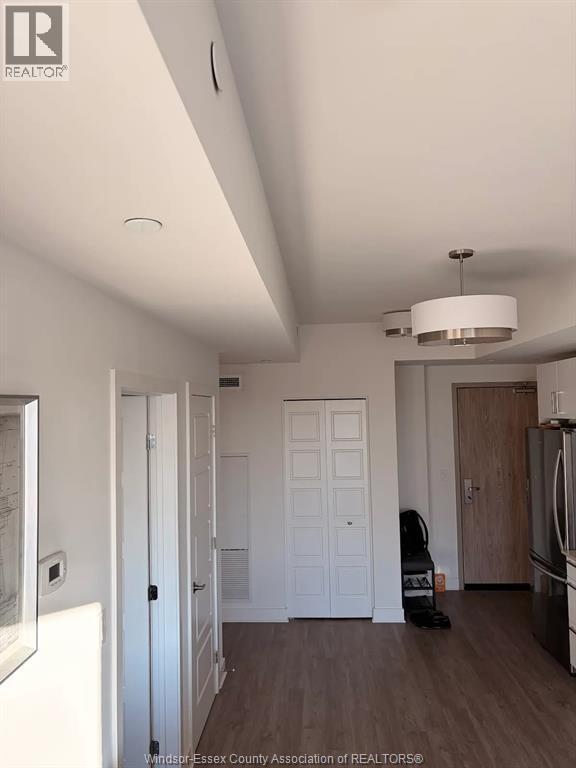 A kitchen with a fridge, a stove and a dining table.