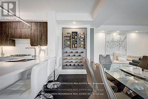 A modern kitchen with white chairs and a wine rack.