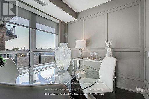 A modern living room with a glass table and white chairs.