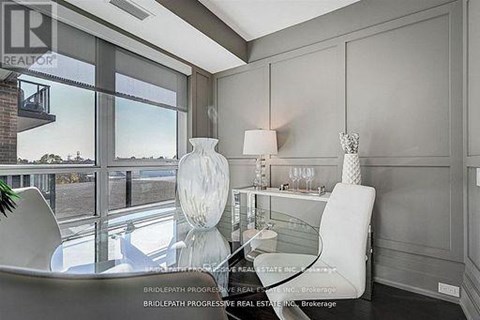 A modern living room with a glass table and white chairs.