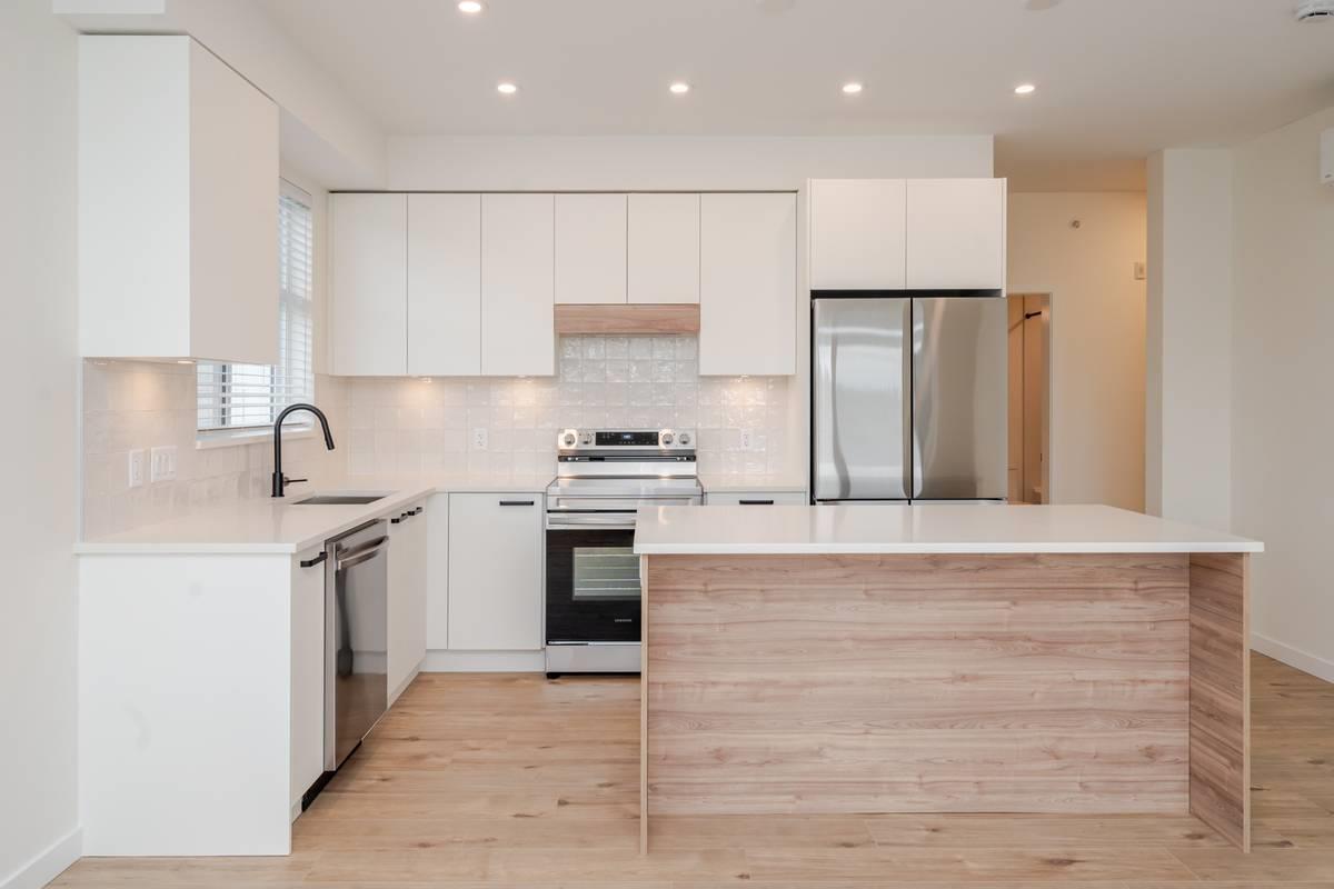 A modern kitchen with white cabinets and a wooden island.