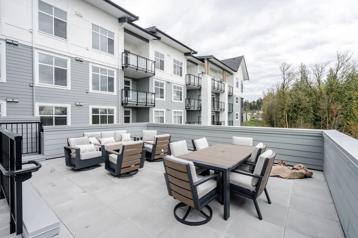 A patio with a table and chairs is in front of a building.