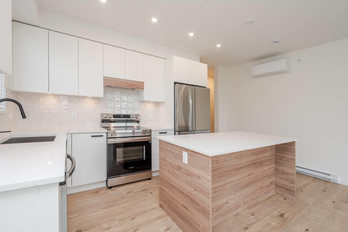 A modern kitchen with a wooden island in the middle.