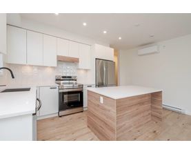 A modern kitchen with a wooden island in the middle.