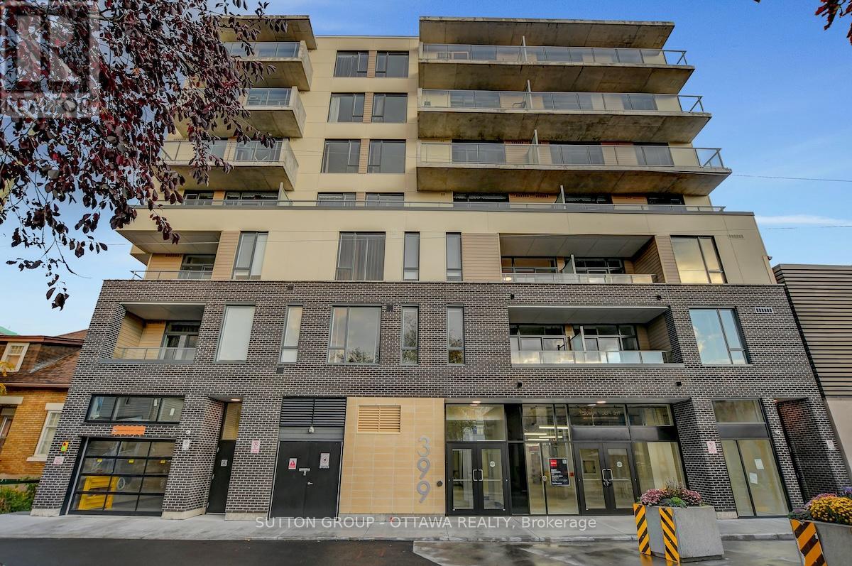 A modern multi-story building with a flat roof and a balcony on the top floor.