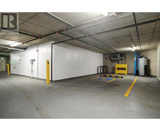 A large, empty warehouse space with a white wall and yellow safety lines on the floor.