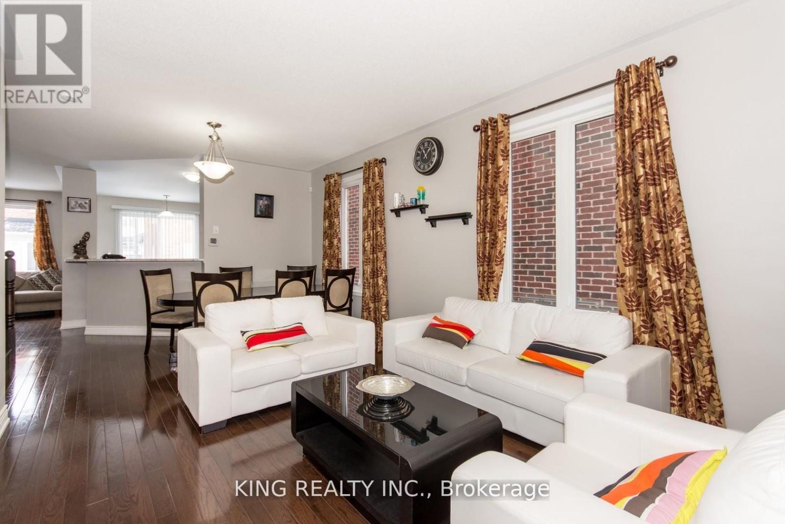 A living room with a white couch and a wooden floor.