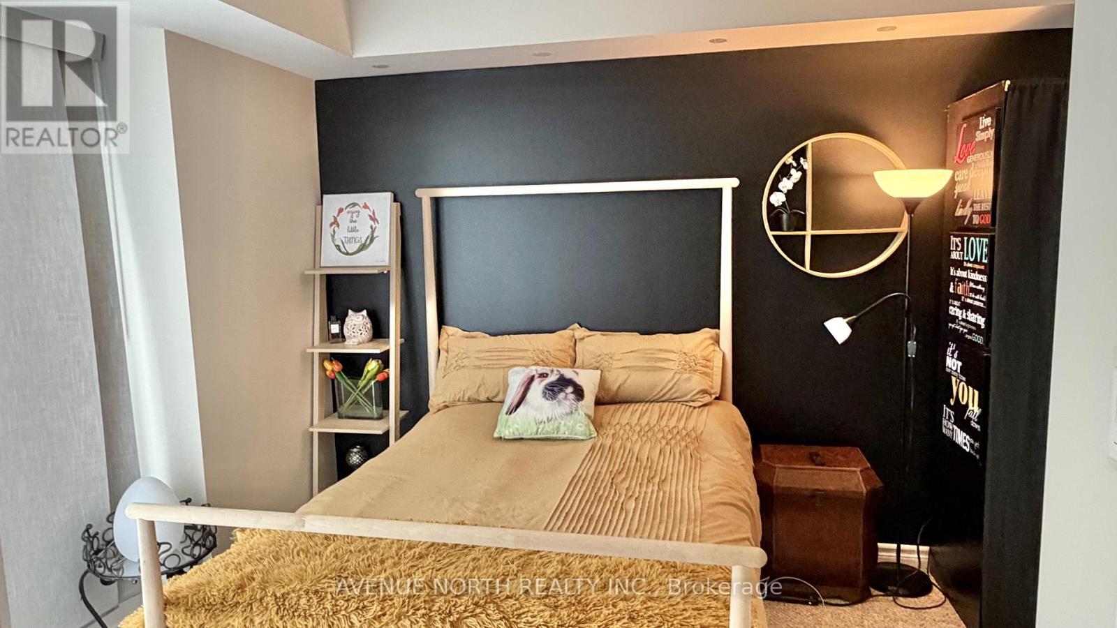 A bedroom with a bed, nightstand, and a lamp.