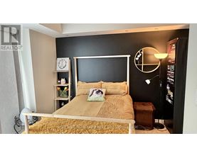 A bedroom with a bed, nightstand, and a lamp.