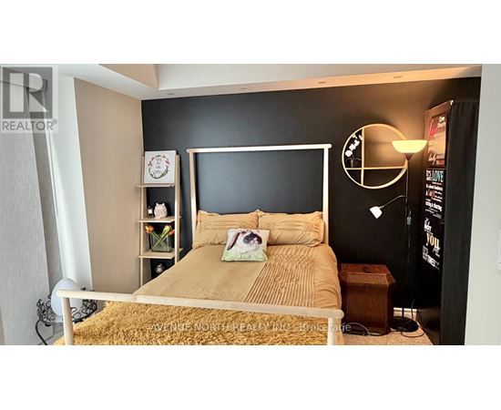A bedroom with a bed, nightstand, and a lamp.