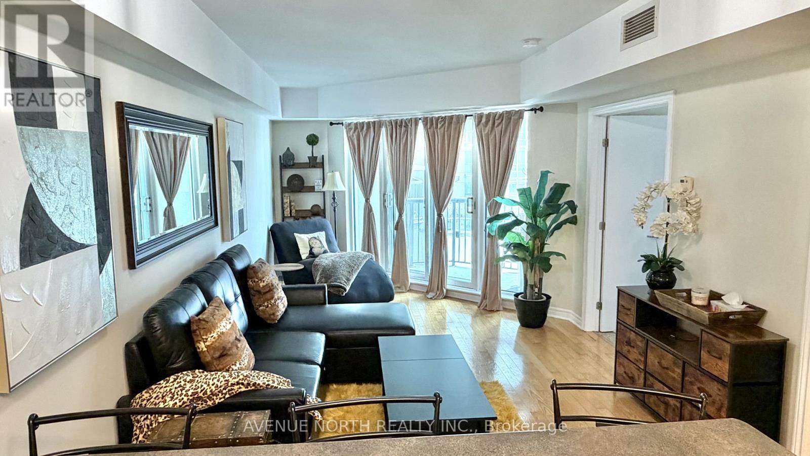A living room with a black couch and a coffee table.
