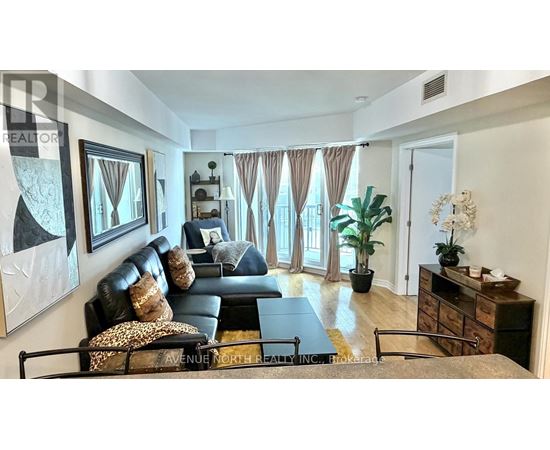A living room with a black couch and a coffee table.