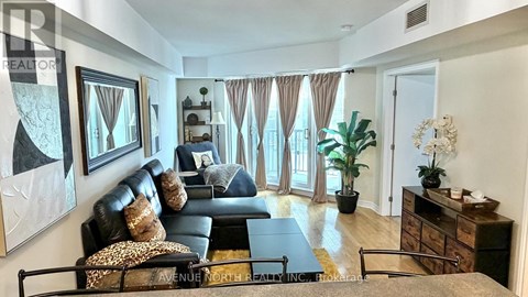 A living room with a black couch and a coffee table.