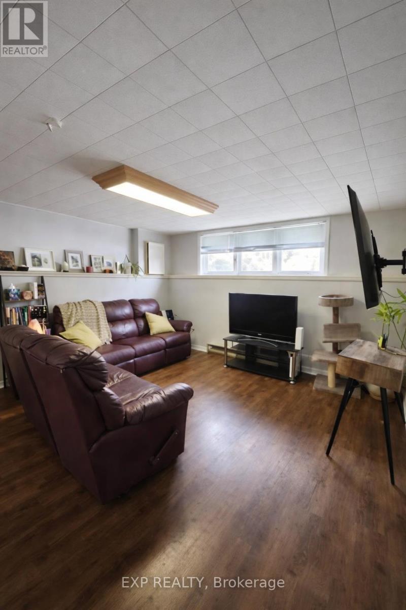 A living room with a brown leather couch and a flat screen TV.