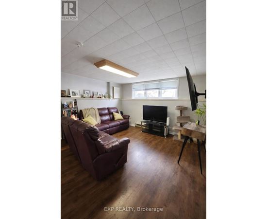 A living room with a brown leather couch and a flat screen TV.