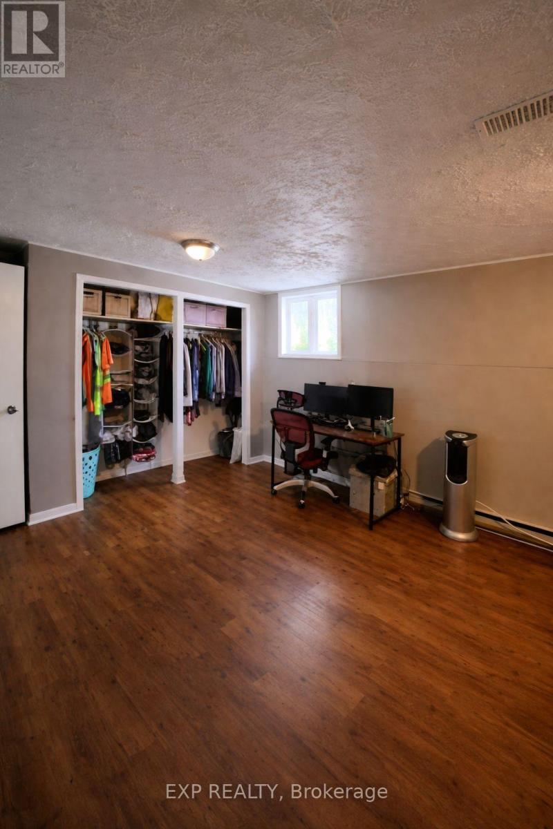 A room with wood flooring and a TV in the corner.