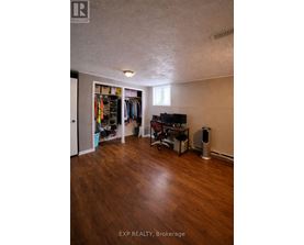A room with wood flooring and a TV in the corner.