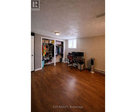 A room with wood flooring and a TV in the corner.