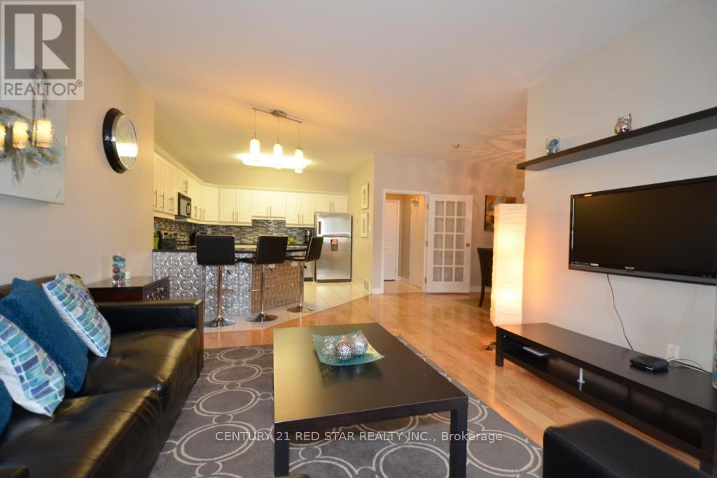 A living room with a black couch and a television.