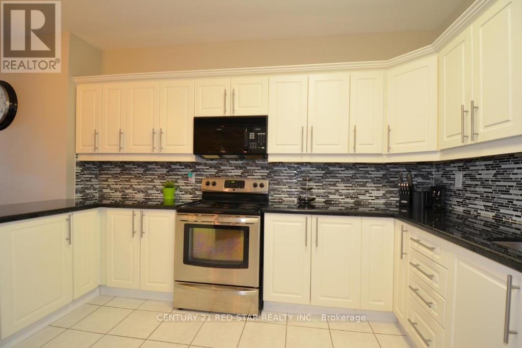 A kitchen with white cabinets and a black stove top.