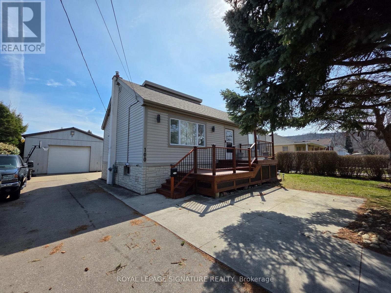 A small house with a deck and a garage.