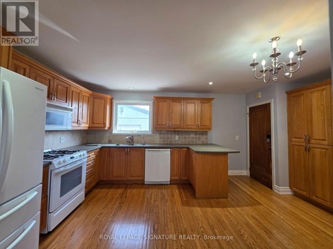 A kitchen with wooden cabinets and a white refrigerator.