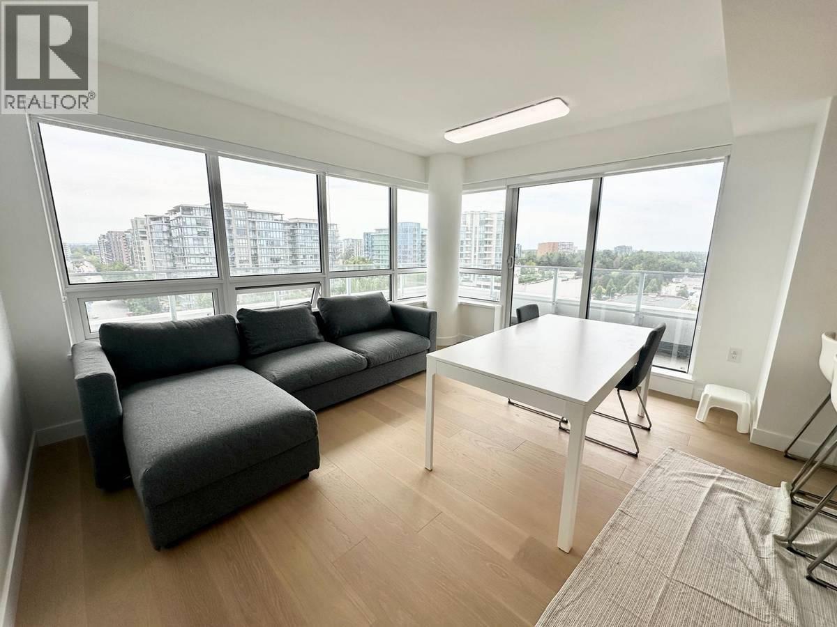 A living room with a grey couch and a white table.