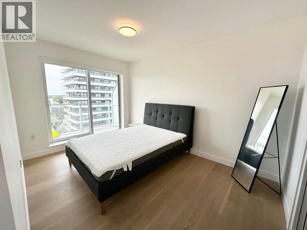 A bedroom with a large bed and a sliding glass door.