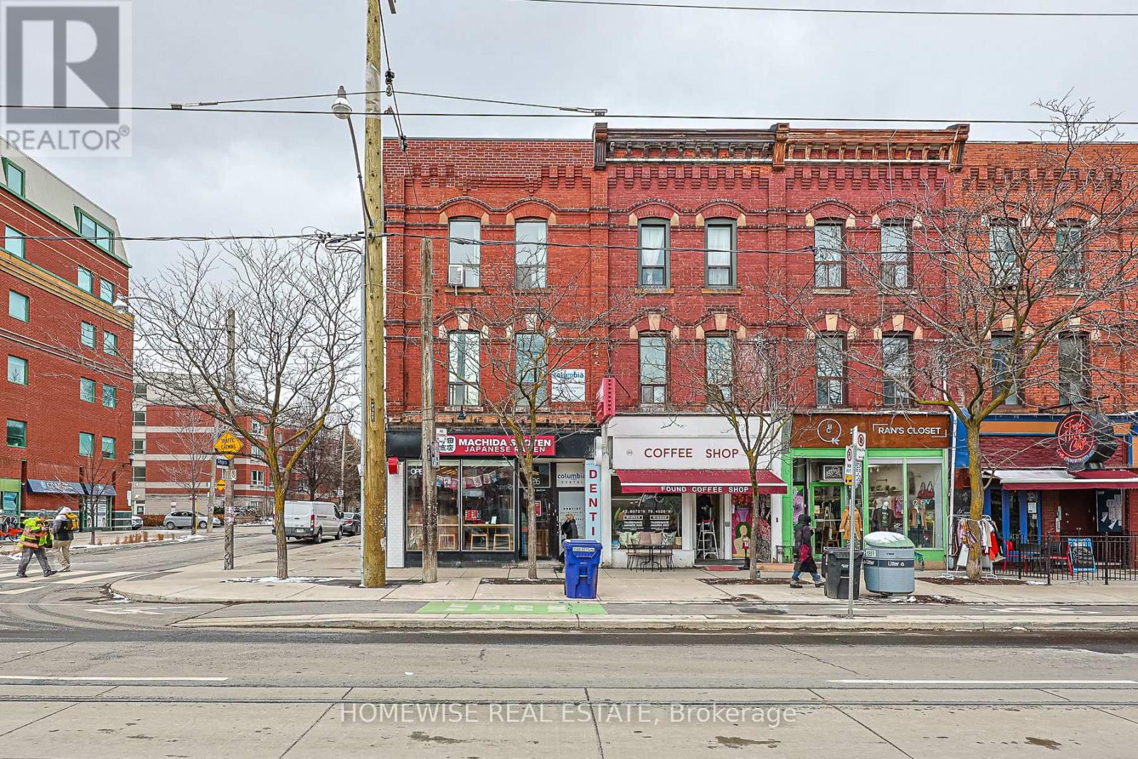 A street view of a city with buildings, a coffee shop, and a Homewise Real Estate Brokerage sign.