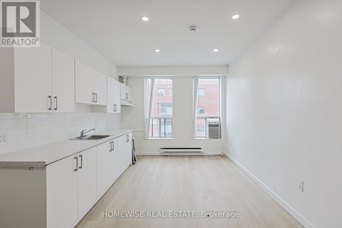 A white kitchen with a sink and cabinets.