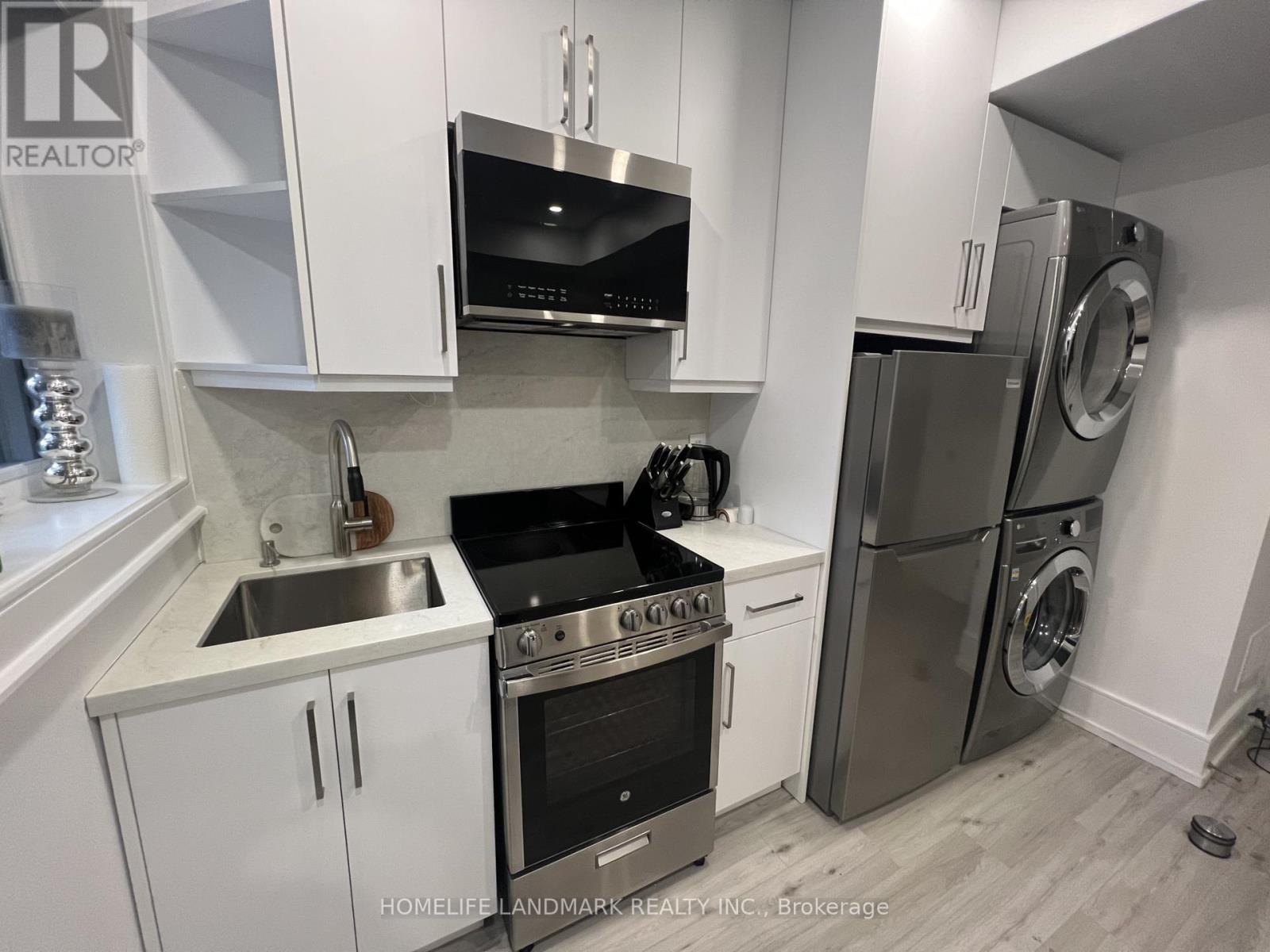 A modern kitchen with white cabinets and stainless steel appliances.