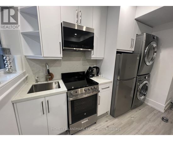 A modern kitchen with white cabinets and stainless steel appliances.