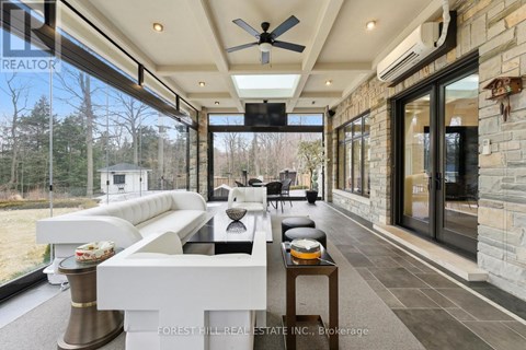 A modern living room with a white sofa and a stone wall.