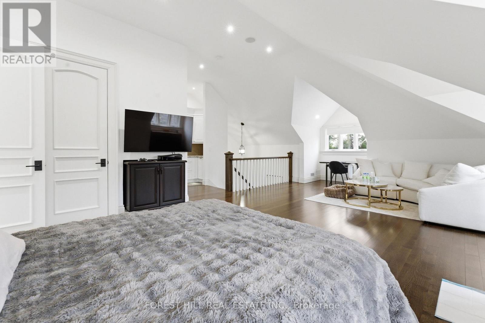 A bedroom with a large bed and a fireplace.
