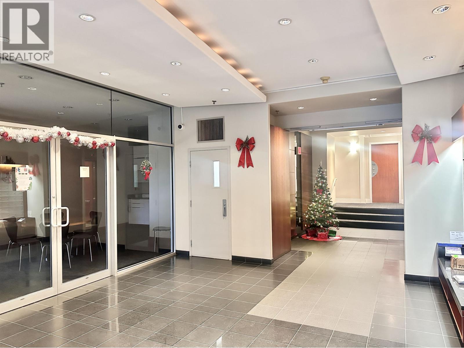 A hallway with a Christmas tree and decorations.
