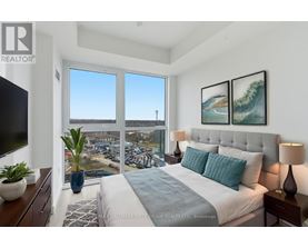 A bedroom with a large bed and a view of a parking lot through the window.
