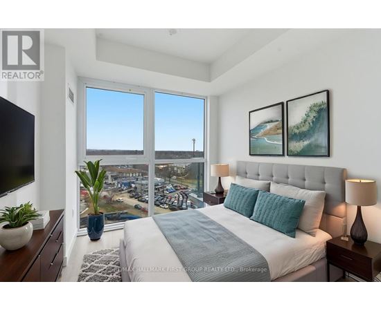 A bedroom with a large bed and a view of a parking lot through the window.