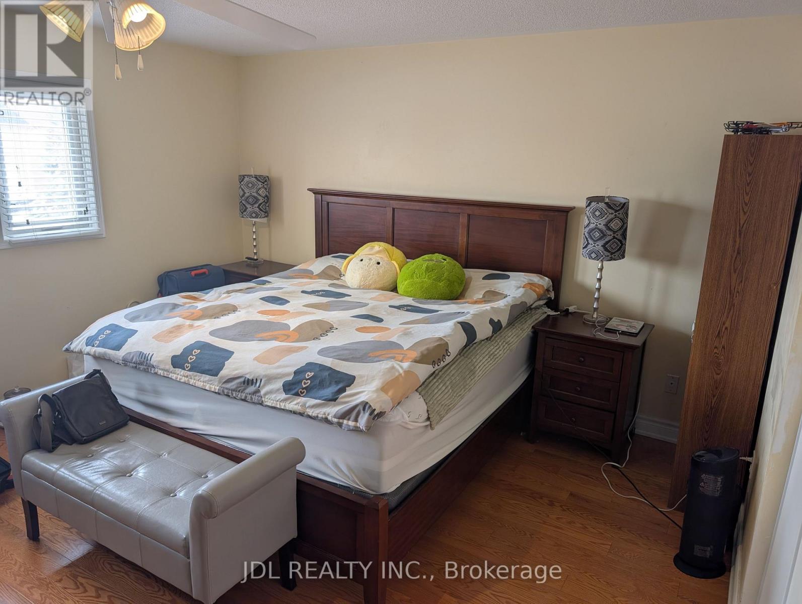 A bedroom with a bed, nightstand, and chair.