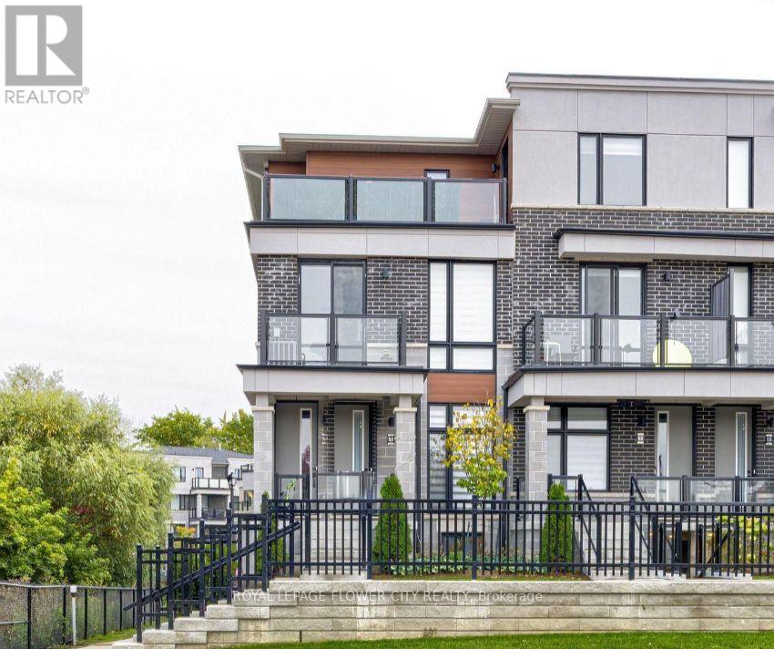 A modern two-story house with a black metal fence in front.