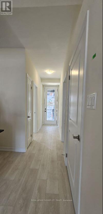 A long hallway with white walls and wood flooring.