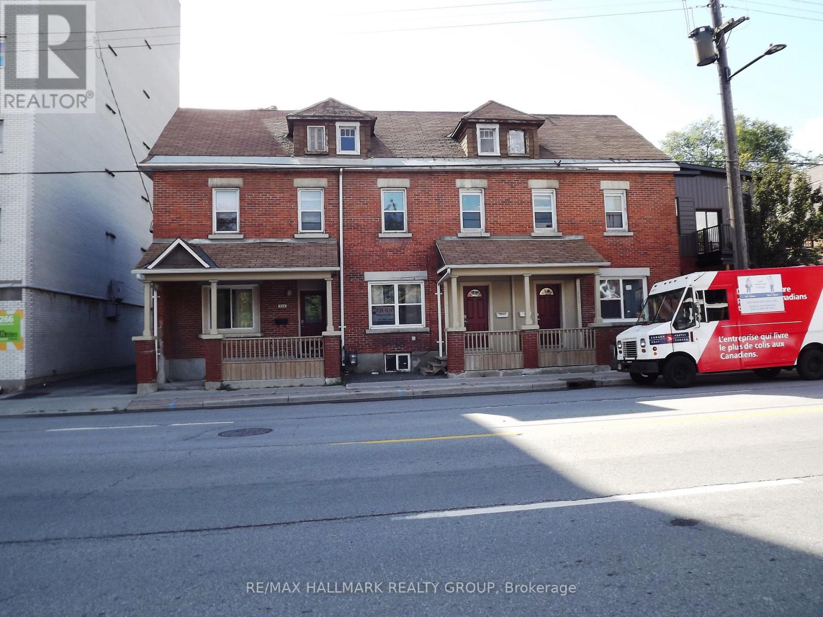 A red brick house with a white truck parked in front.