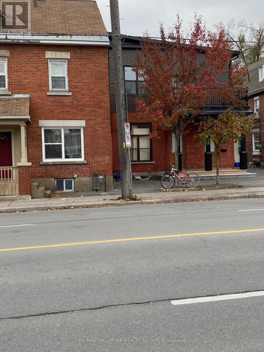 A street view with a red brick building and a bicycle parked on the sidewalk.