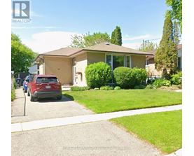 A red car is parked in front of a house with a sign that says REALTOR.
