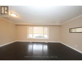 A spacious room with a large window and dark flooring.
