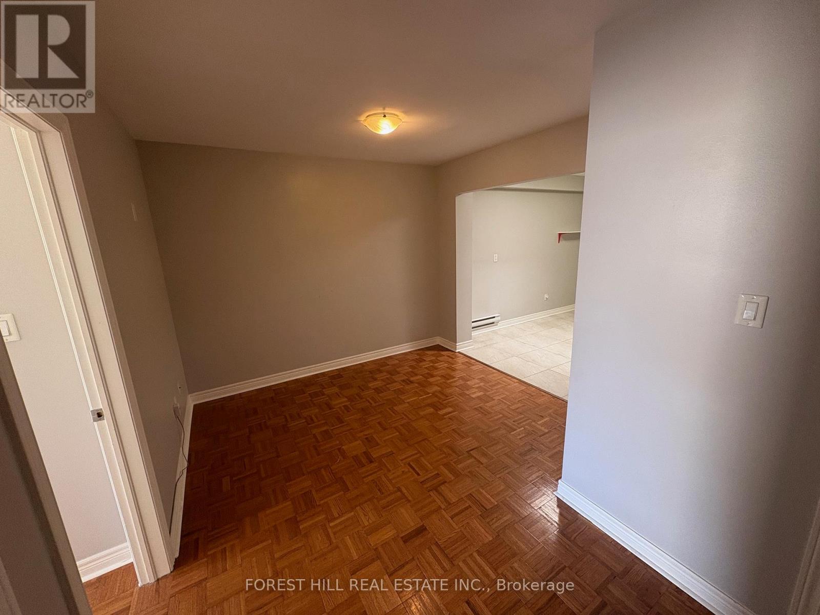 A room with wooden flooring and white walls.