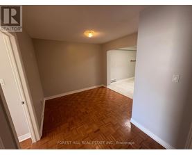 A room with wooden flooring and white walls.